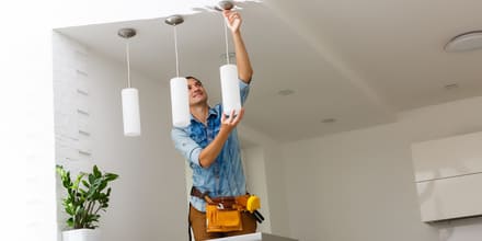 Un homme installant des lustres lumineux